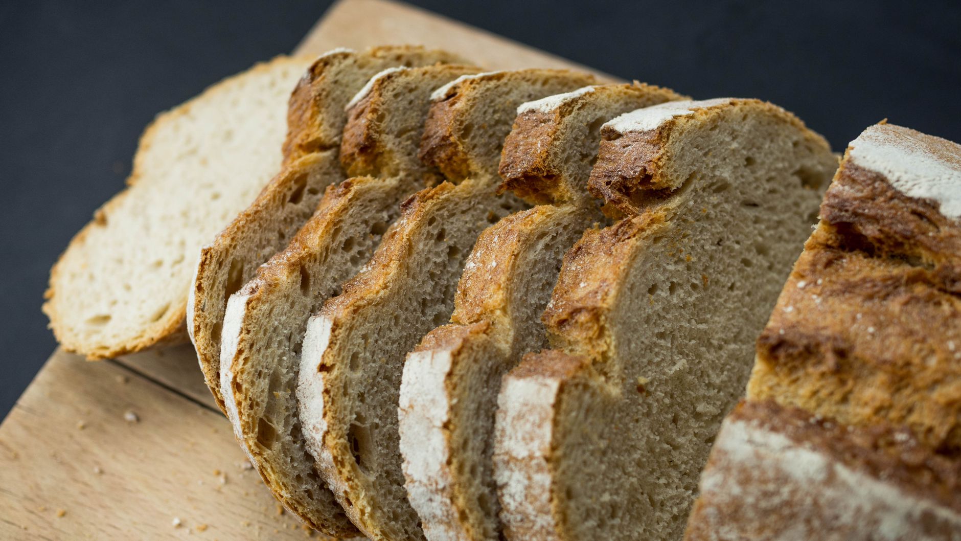 Frissen szeletelt kovászos kenyér fatáblán